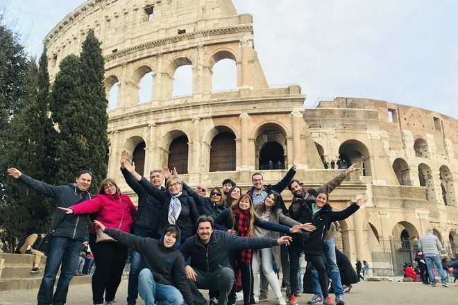 Travelers taking a group picture in front of the Colosseum during a free walking tour in Rome.