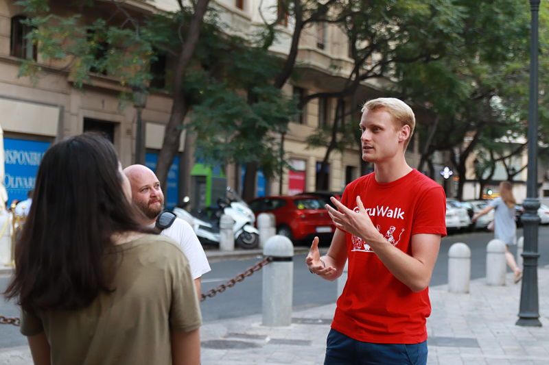 Guide of GuruWalk explaining something to travelers on a free walking tour in Valencia, Spain.