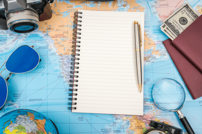 Libro blanco con un boli en un mapa del mundo para preparar un viaje.