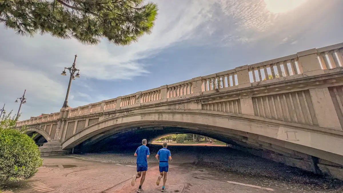 image Dos personas corriendo bajo un puente en el Jardín del Turia, Valencia.