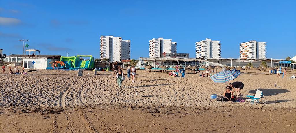 Punta Umbría, playa con edificios y personas disfrutando del sol.