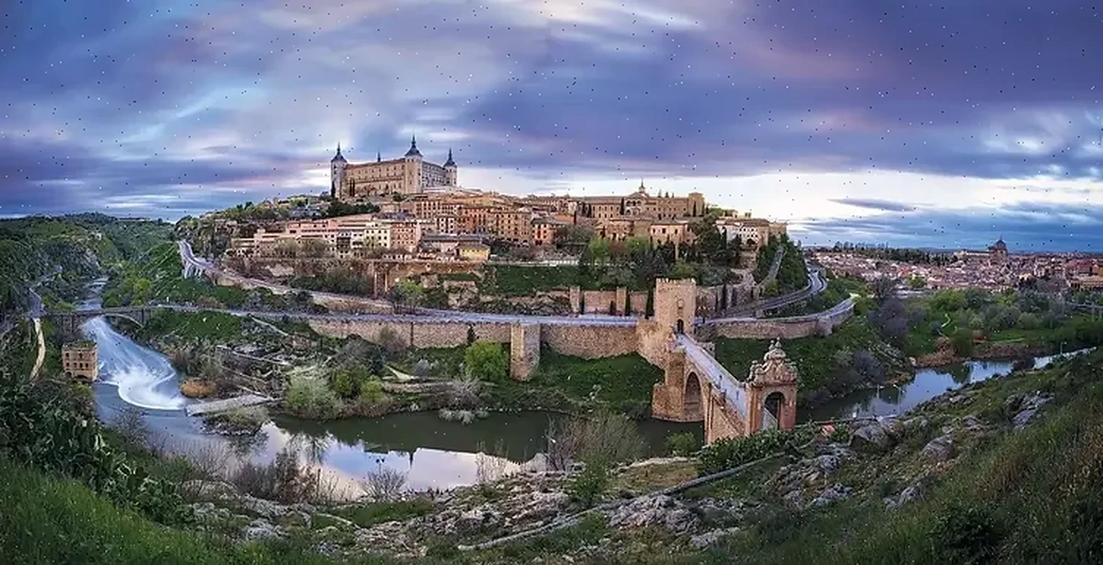 Panorámica de Toledo con el Alcázar y el Puente de San Martín al atardecer, ideal para tours históricos y paisajes urbanos.