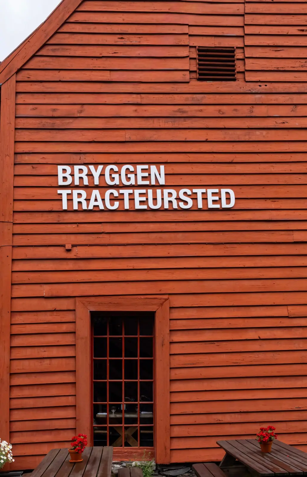 Fachada de madera rojiza de Bryggen Tracteursted en Bryggen, Bergen