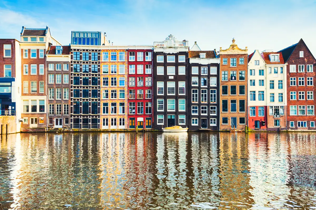 Casas estrechas con frontones tradicionales junto a un canal de Ámsterdam