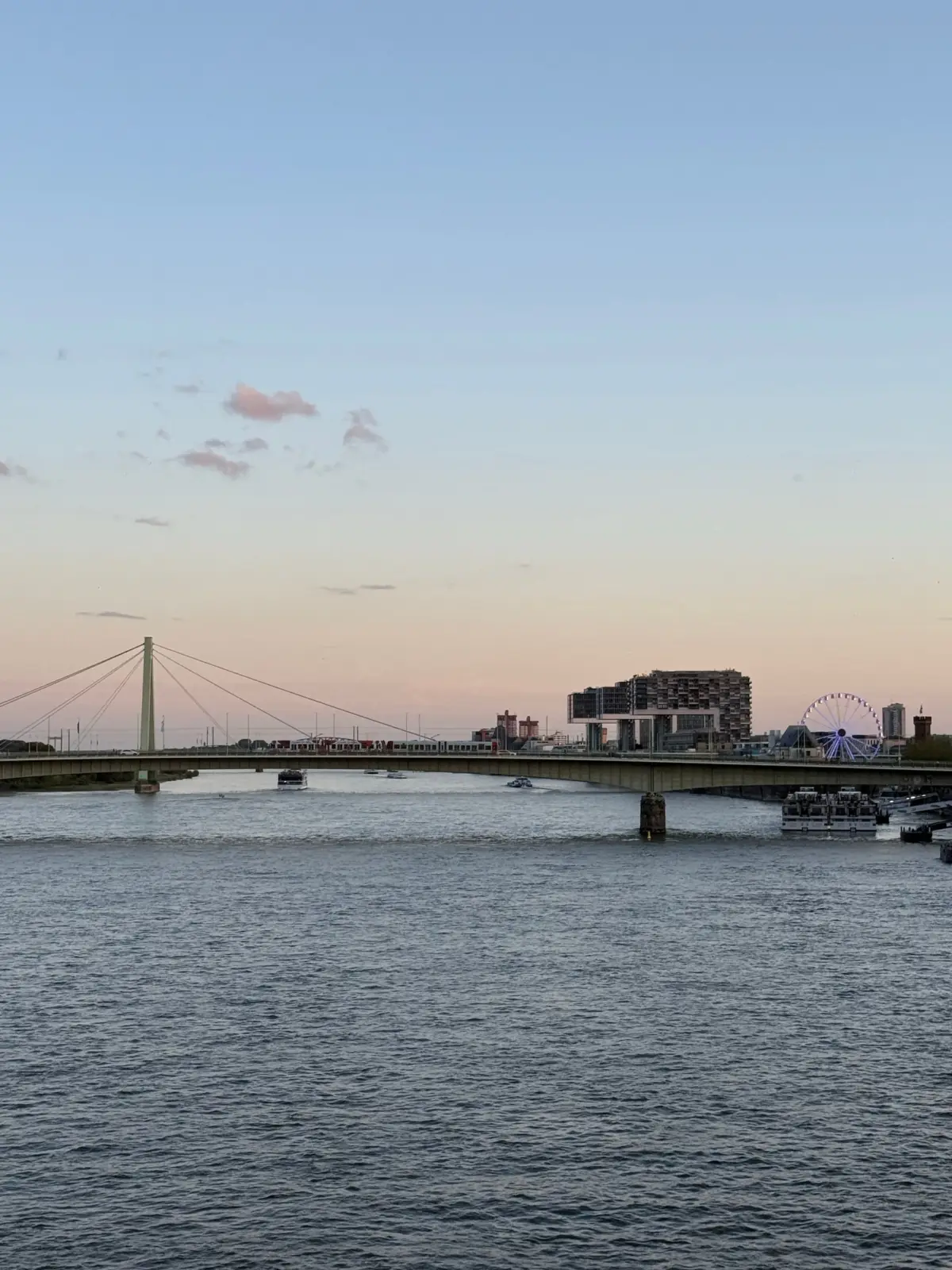 El Rin, un puente y los edificios de Rheinauhafen en Colonia al atardecer