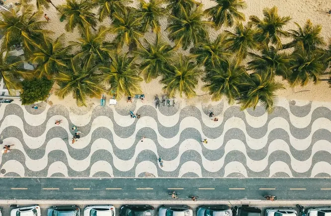 Paseo de Copacabana en Río de Janeiro visto desde arriba, con su mosaico ondulado, palmeras y arena