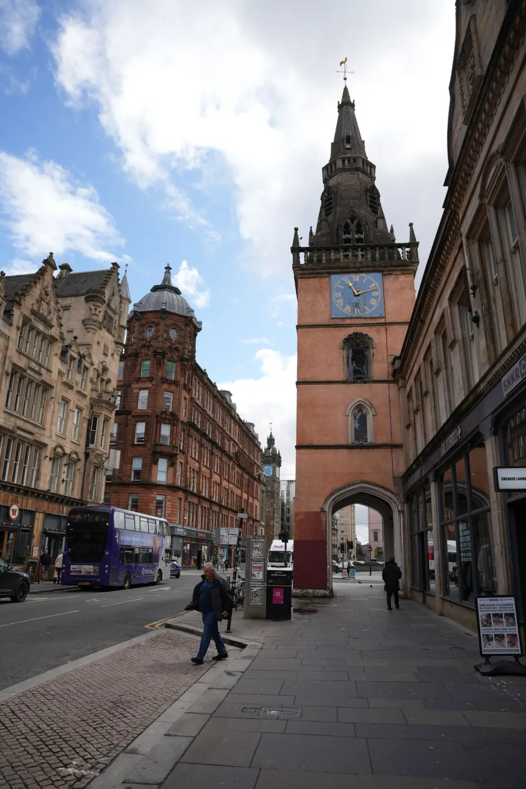 Autobús de dos pisos y peatones junto al Tolbooth Steeple en Glasgow