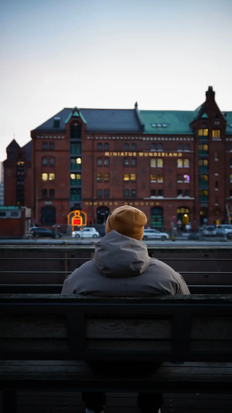 Persona sentada frente a la fachada de Miniatur Wunderland en Hamburgo