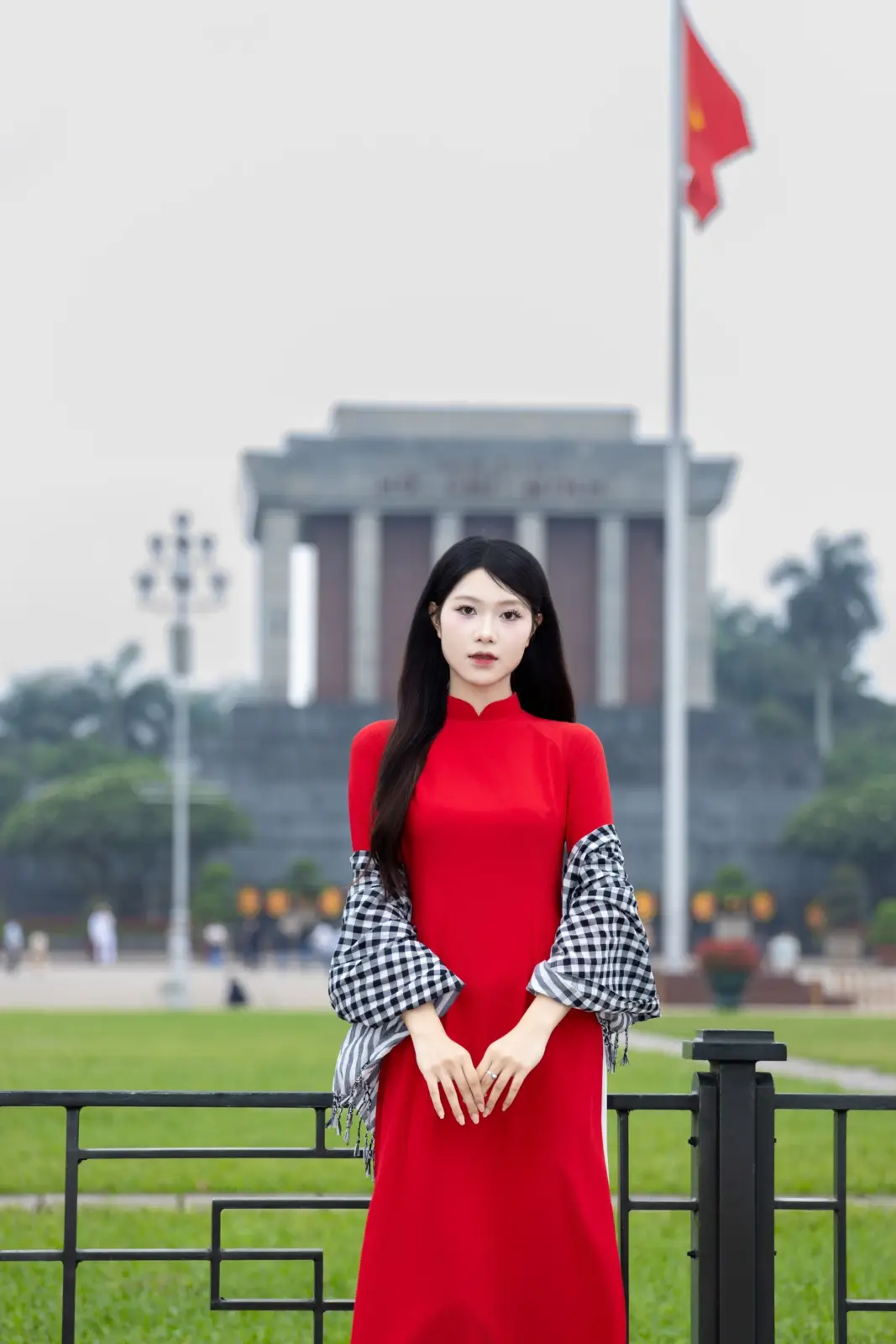Mujer con vestido rojo frente al Mausoleo de Hồ Chí Minh en la plaza Ba Đình de Hanói