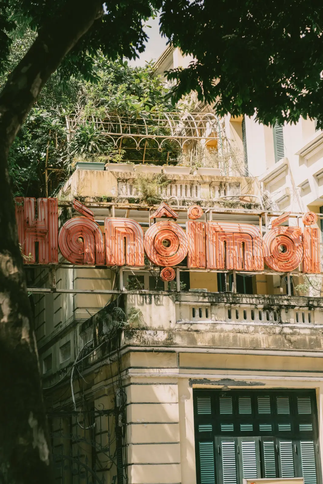 Fachada del Hotel Métropole entre árboles en el barrio francés de Hanói