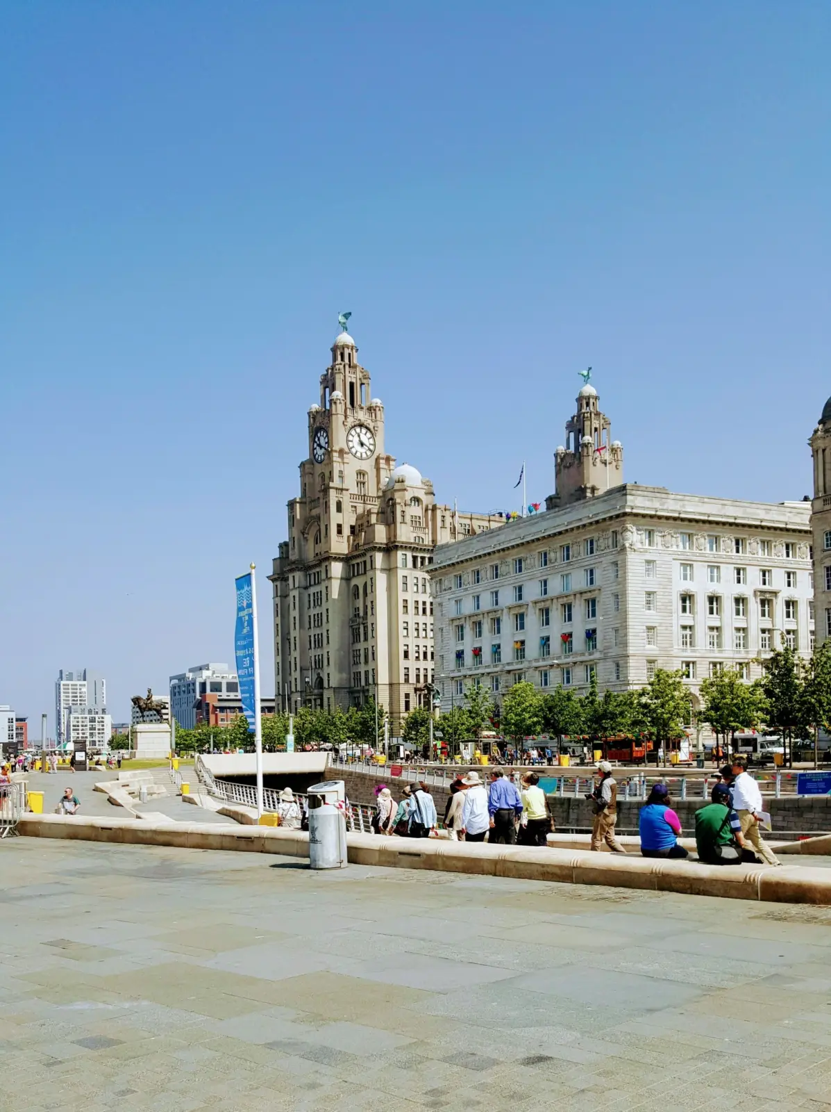 Visitantes en Pier Head ante el Royal Liver Building de Liverpool
