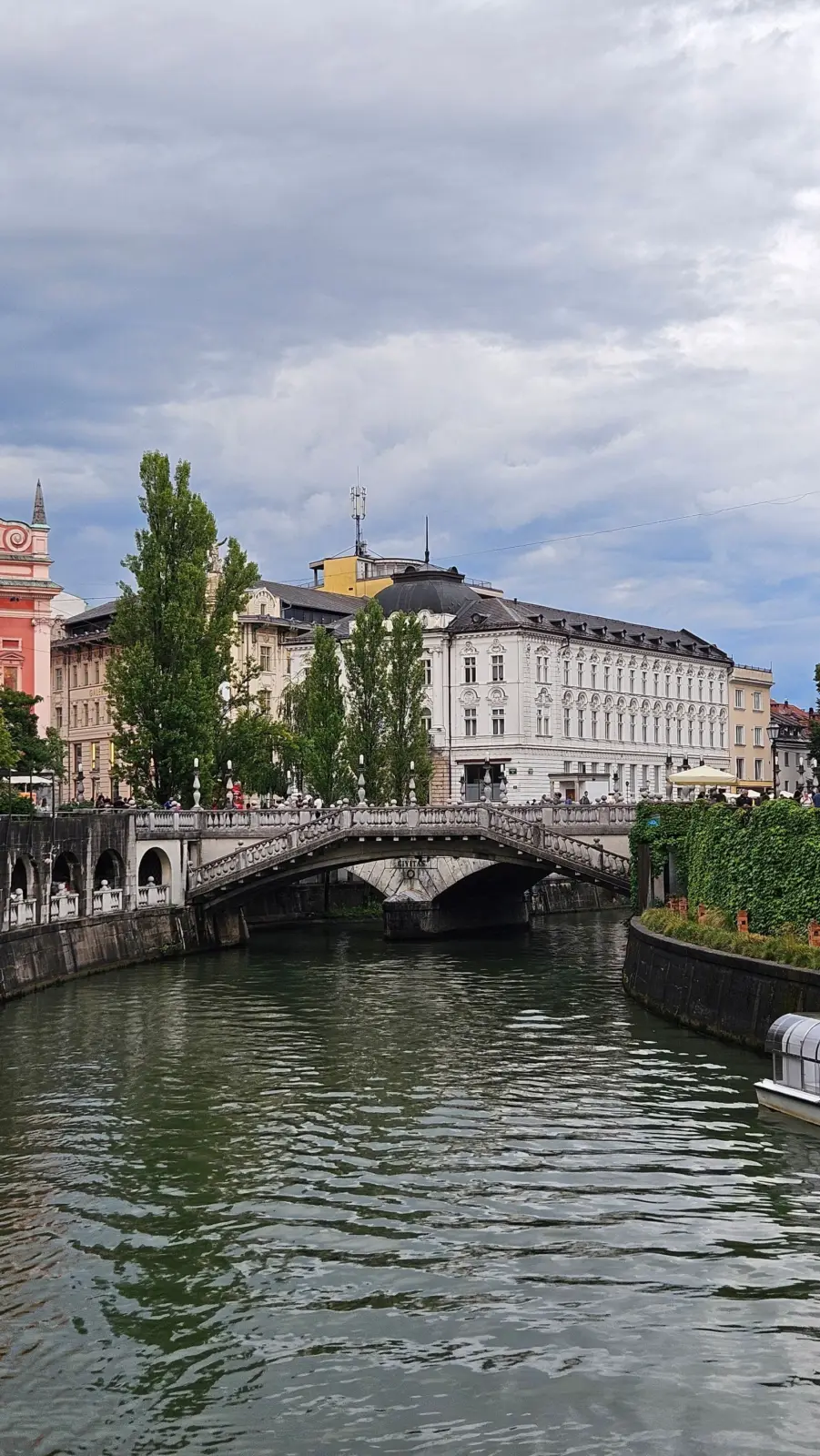 Puente Triple sobre el río Ljubljanica, con peatones y edificios históricos de Liubliana