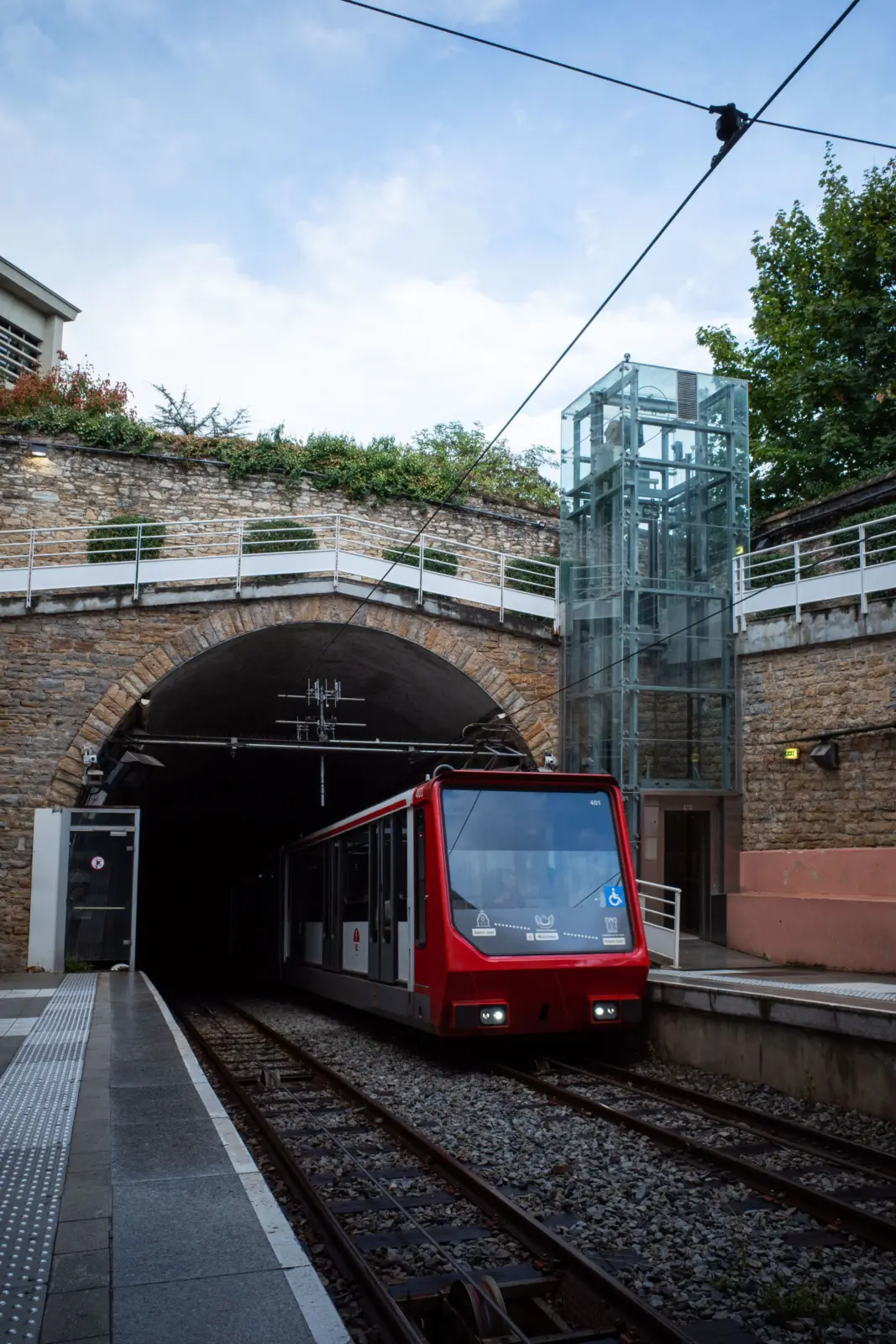 Funicular rojo en una estación de Lyon junto a la entrada de un túnel