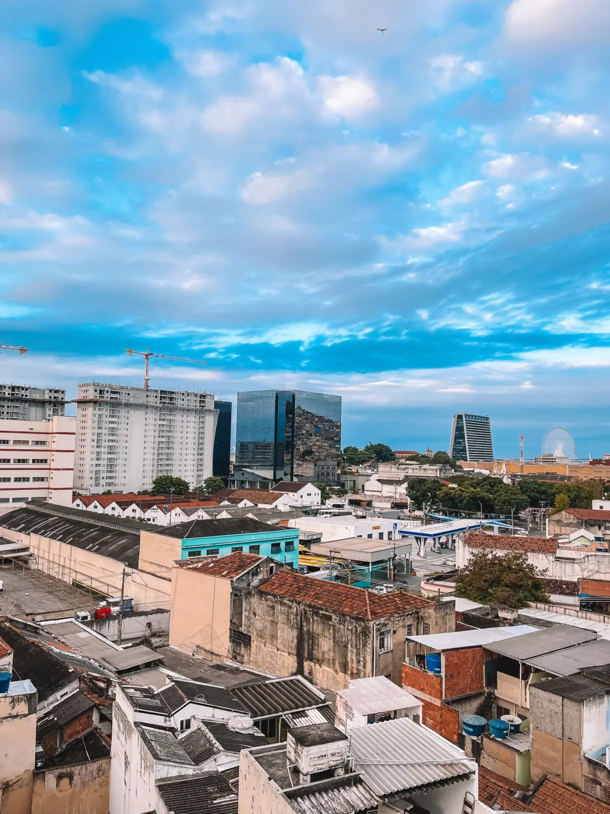 Vista elevada de la zona portuaria de Río de Janeiro, con edificios, almacenes y una noria al fondo