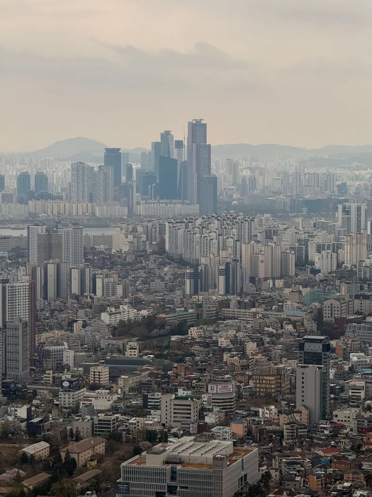 Vista panorámica de Seúl con barrios densos y rascacielos al fondo