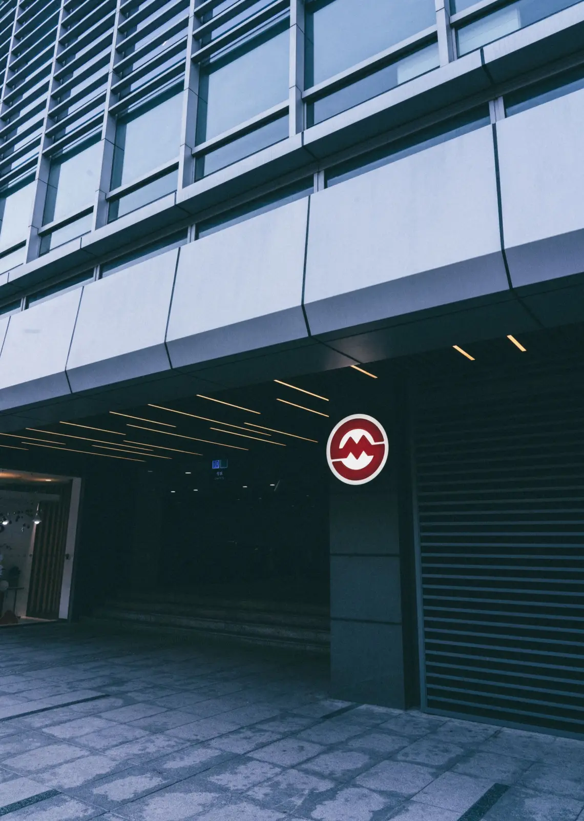 Entrada al metro de Shanghái con su distintivo circular rojo y blanco