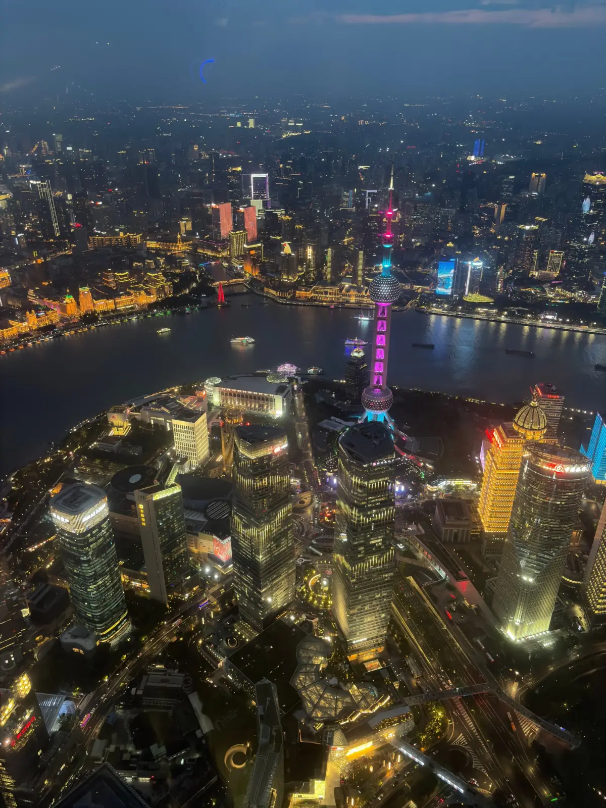 Vista aérea nocturna de Shanghái con la Torre de la Perla Oriental y el río Huangpu