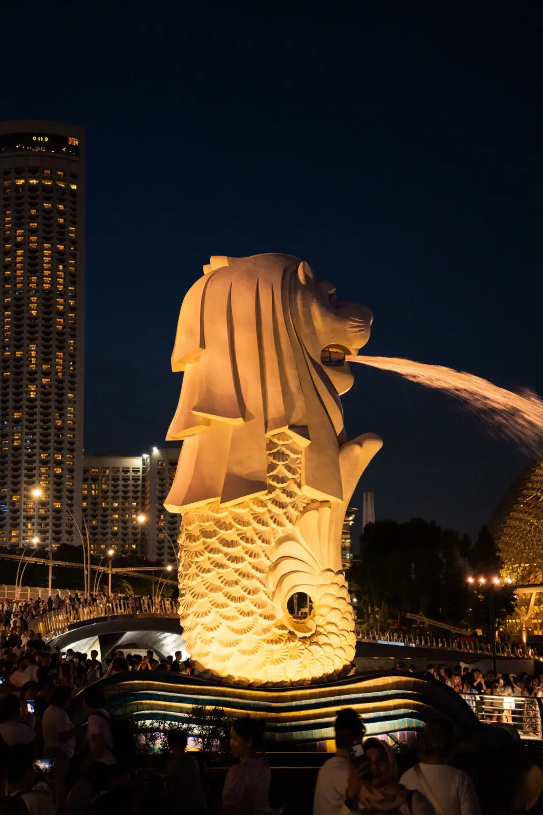 Merlion iluminado por la noche ante los visitantes de Marina Bay, Singapur