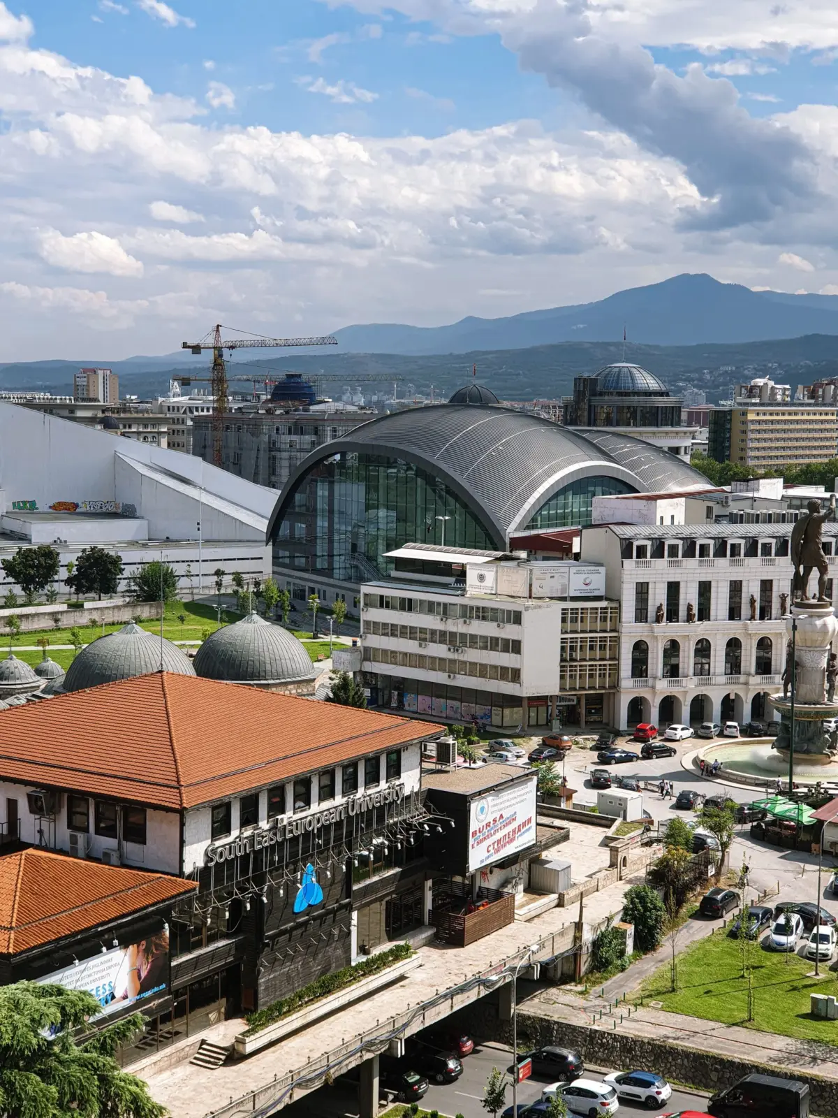 Vista elevada del centro de Skopje con edificios y montañas al fondo