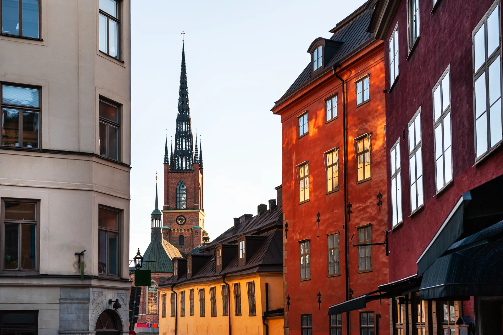 Gamla Stan street with colourful houses and a church spire in Stockholm