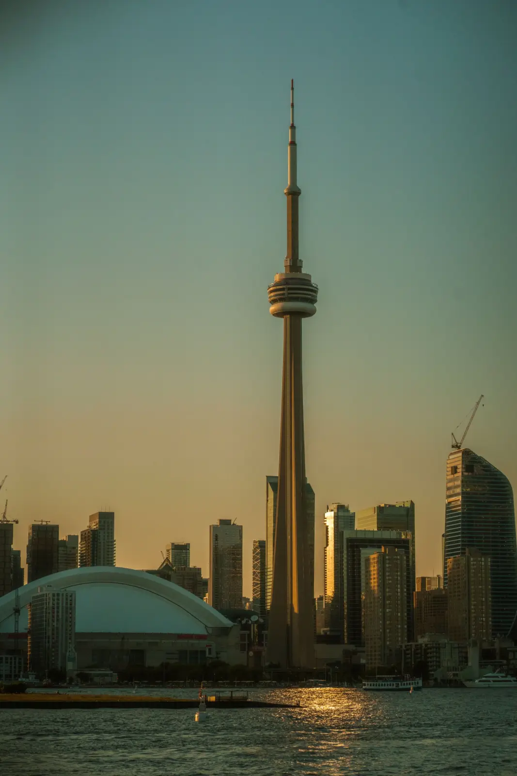 CN Tower and the Toronto skyline across the waterfront at sunset