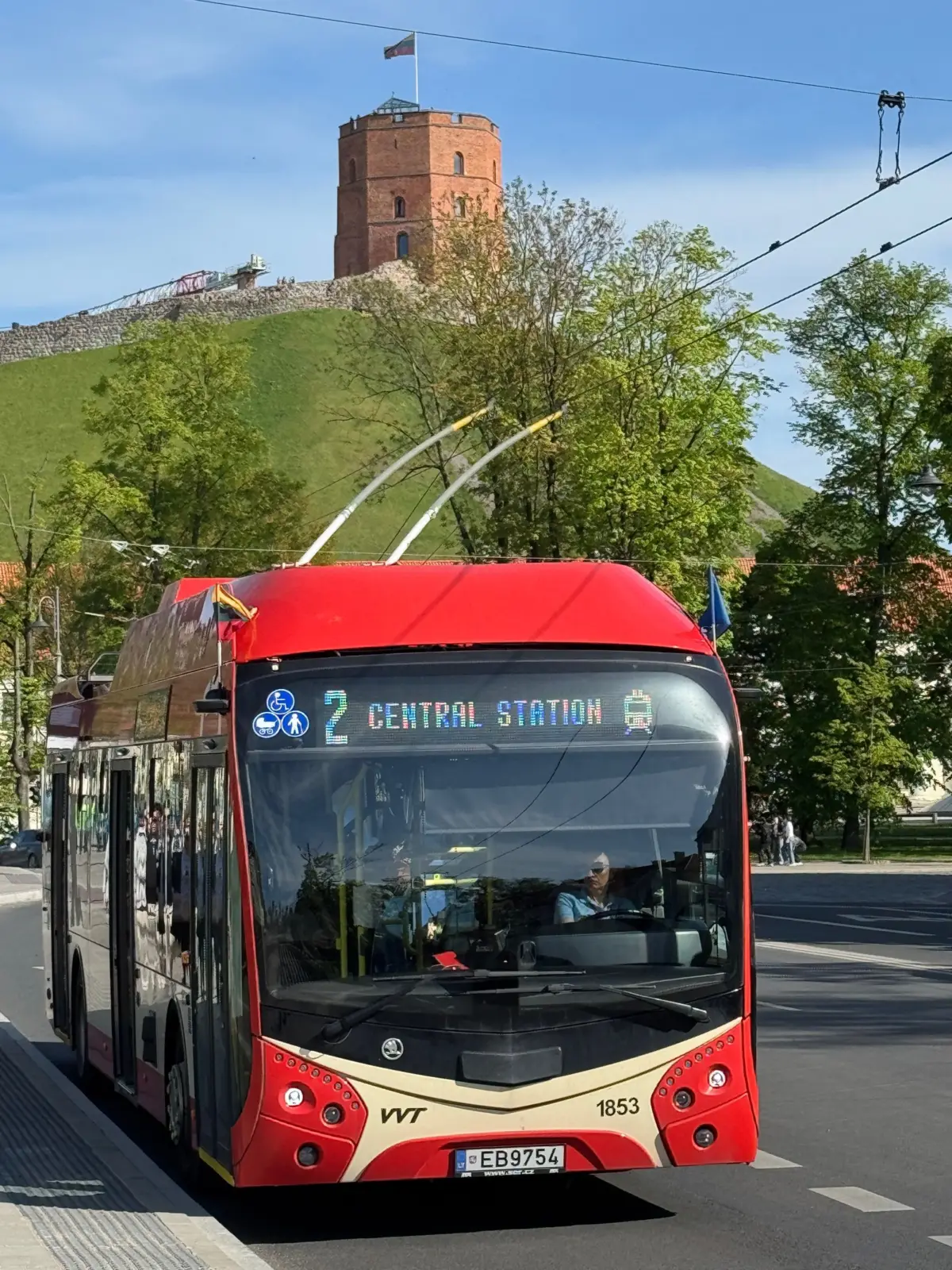 Trolebús rojo de Vilnius frente a la torre de Gediminas