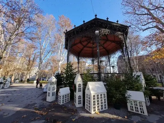Quiosco de música de Zrinjevac rodeado de abetos y casas decorativas blancas en Zagreb