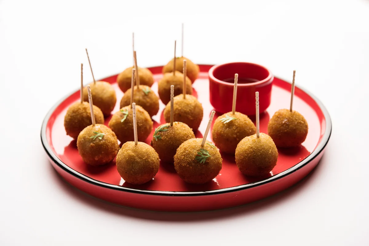 A plate of Portuguese cod fritters, bolinhos de bacalhau, served with cocktail sticks